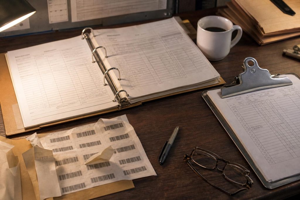 Food traceability plan documents and lot code labels on a plant office desk.
